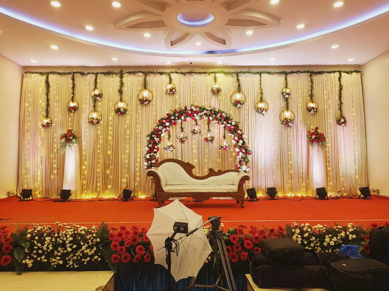 Stage with a floral arch and hanging lanterns