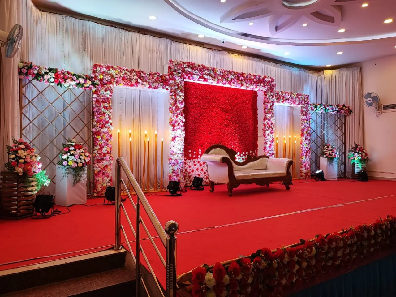 Stage with red rose wall and carved sofa