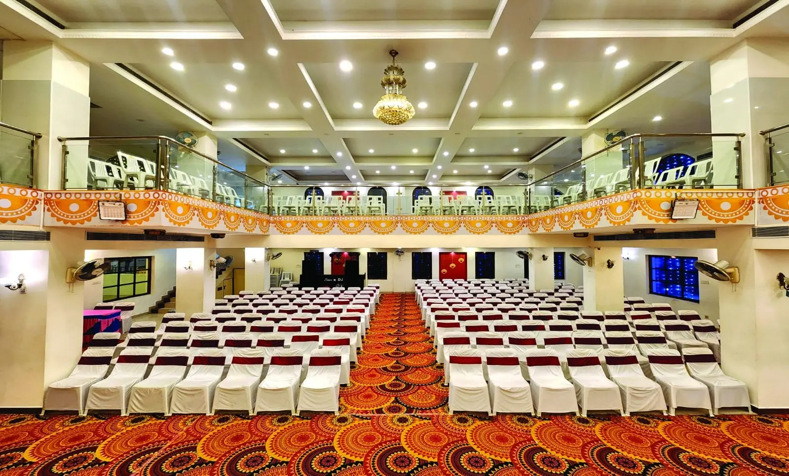 Inside the Mega Hall: rows of seating, carpet aisle and balcony